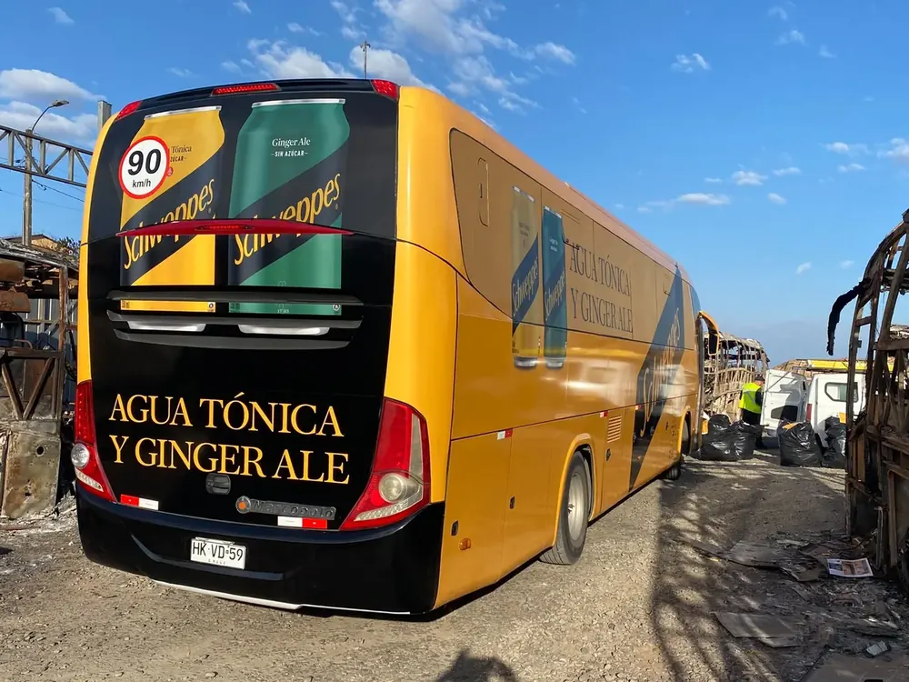 Bus intervenido con gráfica publicitaria amarilla y negra